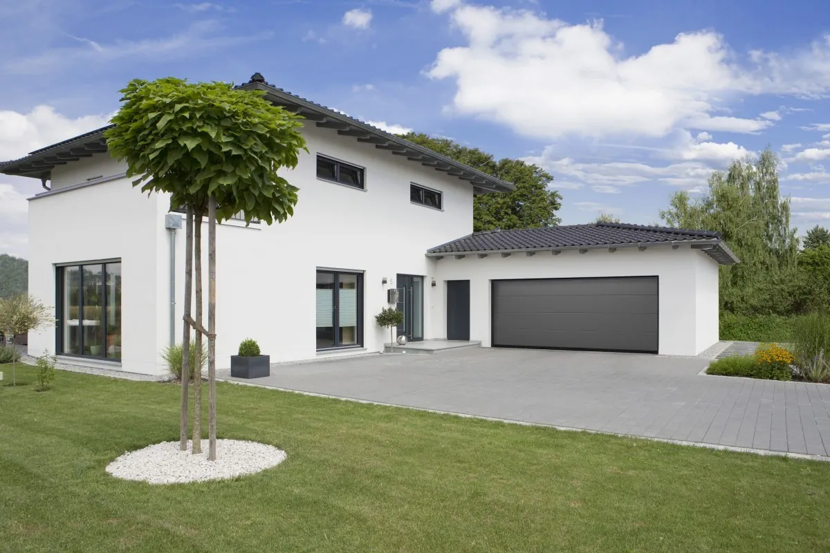 Weißes Einfamilienhaus mit anthrazitfarbenem Normstahl-Sektionaltor in der Doppelgarage